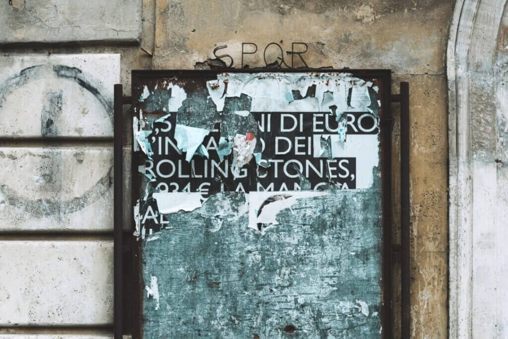 Überreste eines Plakats auf einer Reklame Wand