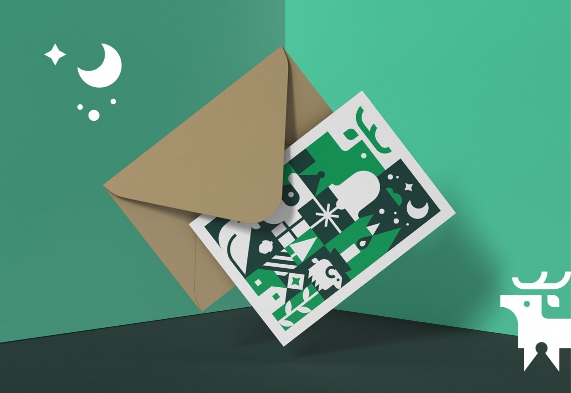 Brauner Umschlag mit einer Weihnachtskarte, die grüne und weiße festliche Symbole zeigt, auf grünem Hintergrund