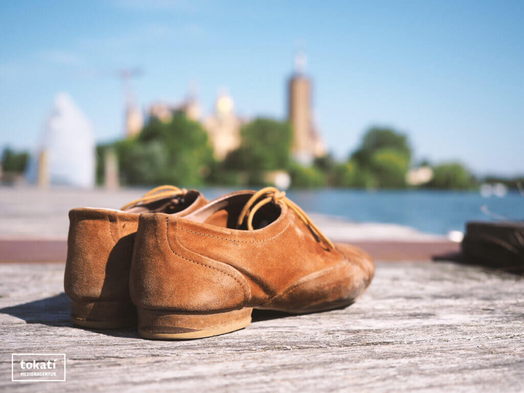 Schuhe auf einem Steg mit Schweriner Schloss im Hintergrund