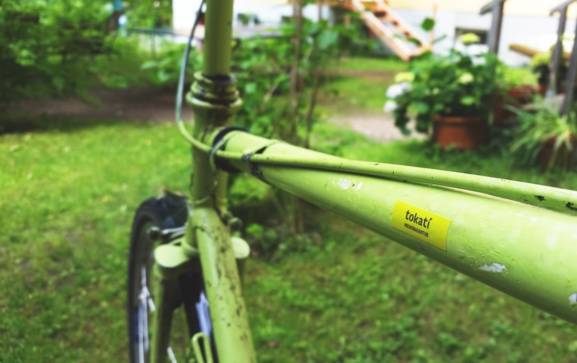 Nahaufnahme eines grünen Fahrradrahmens im Garten