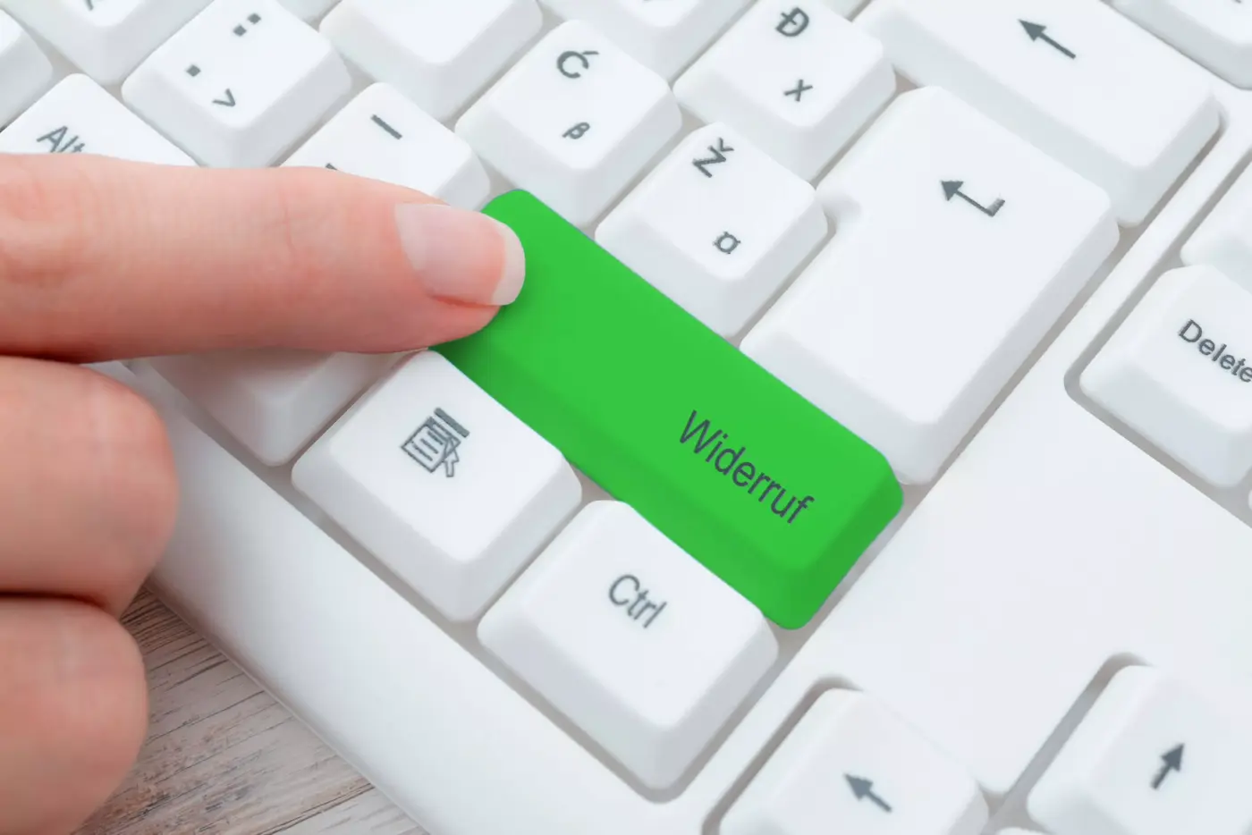 finger drückt grünen widerrufsbutton auf tastatur